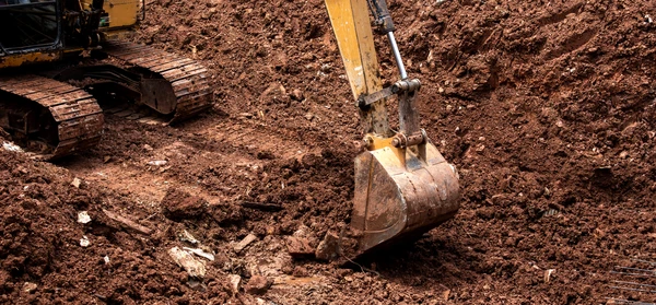 Chantier de terrassement en ext&eacute;rieur avec pelleteuse hydraulique sur chenilles en action