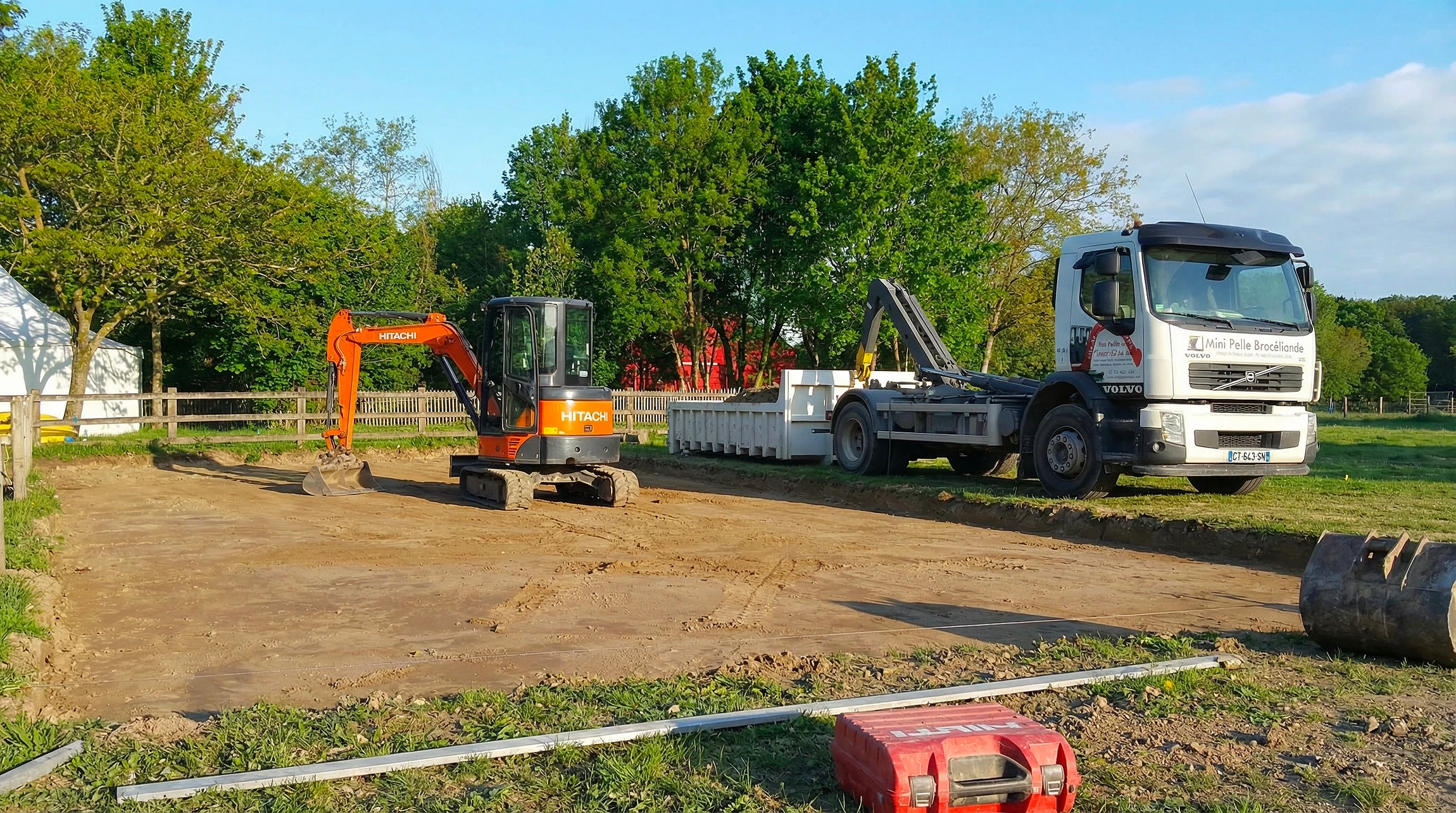 Chantier de terrassement en extérieur avec pelleteuse hydraulique sur chenilles de couleur jaune positionnée en bordure d'excavation