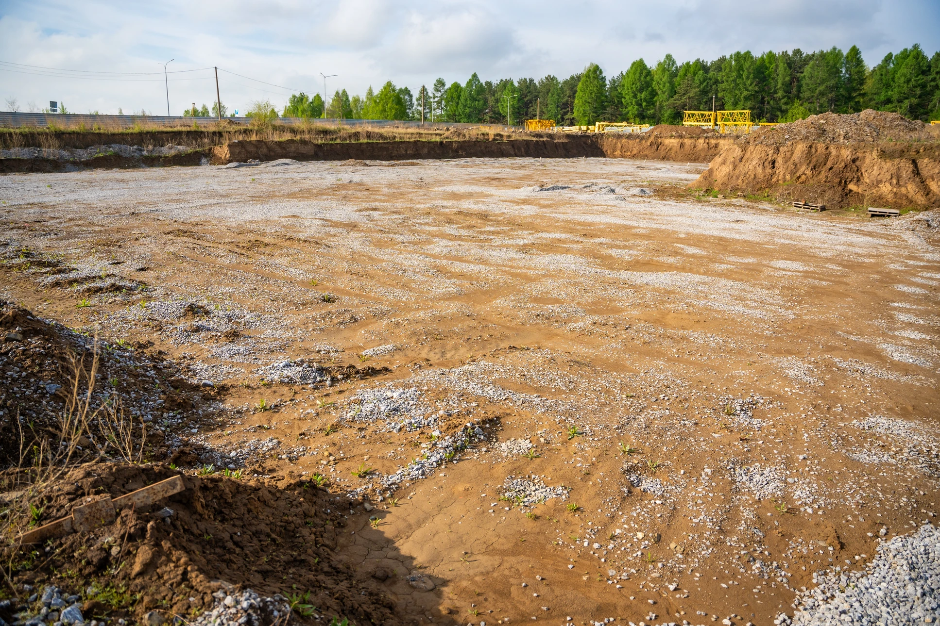 Chantier de construction en extérieur avec pelleteuse hydraulique jaune en action sur terrain sablonneux