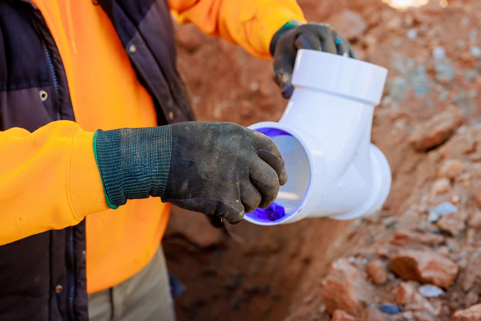 Atelier de plomberie avec outils professionnels disposés sur établi en bois