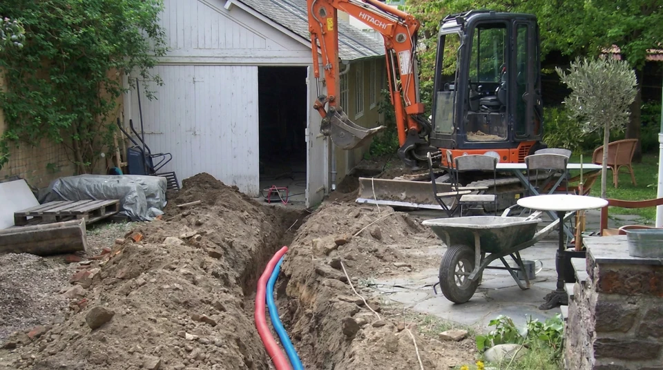 Chantier de terrassement en extérieur avec pelleteuse sur pneus déversant du sable ou terre excavée