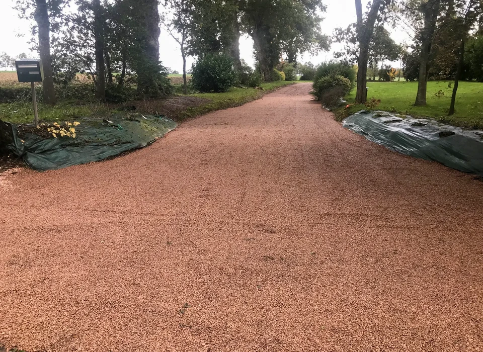 Chantier de terrassement résidentiel avec mini-pelle jaune en action dans excavation entre maisons