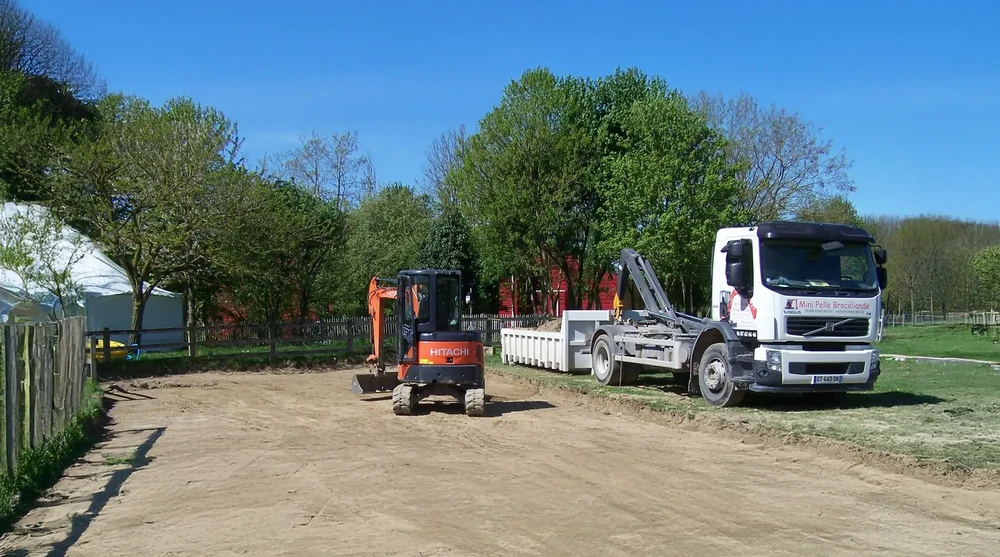 Chantier extérieur résidentiel avec terrain en préparation devant maison moderne à bardage bois